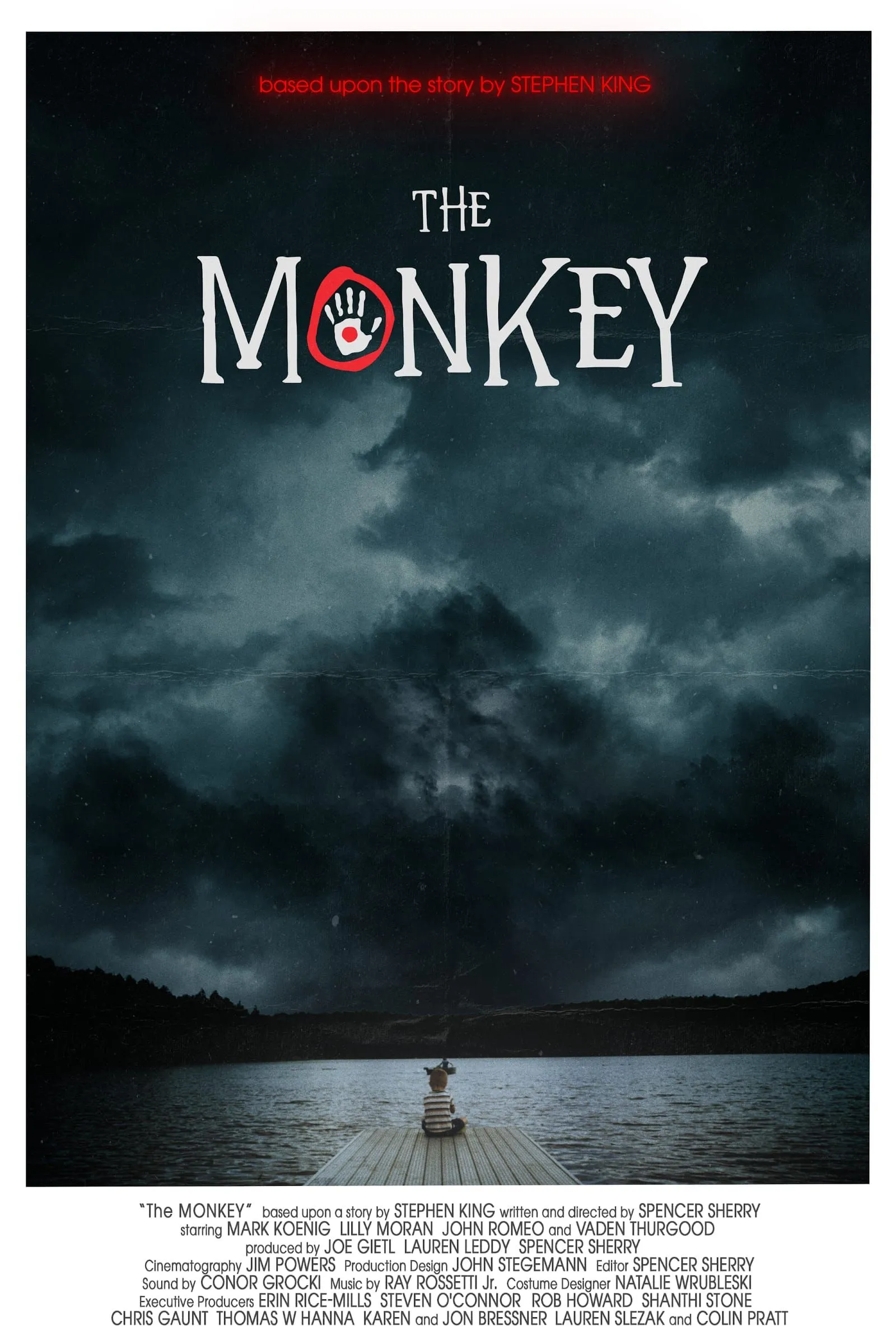 The Monkey poster — a still, dark lake at dusk beneath a stormy sky, the title set with a red handprint.